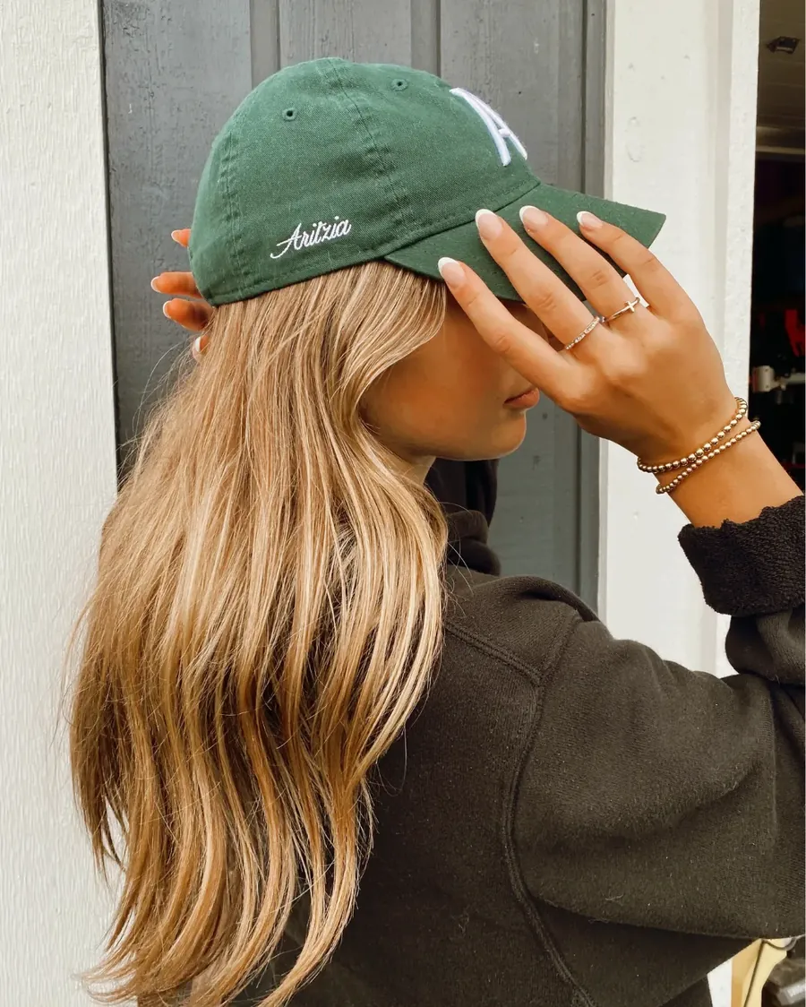 Cabelo loiro e boné verde